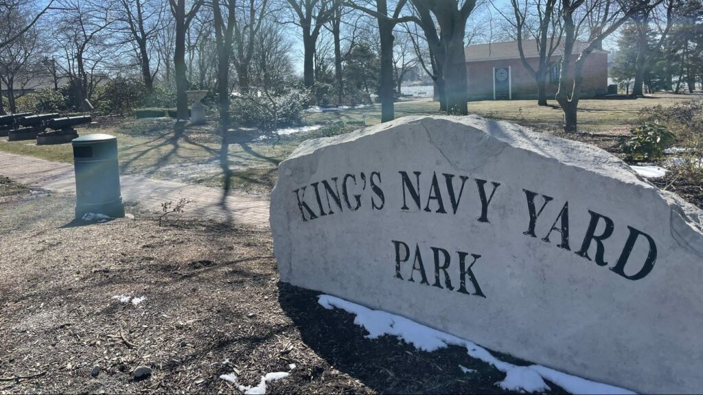A picture with a stone that has the words Kings Navy Yard Park